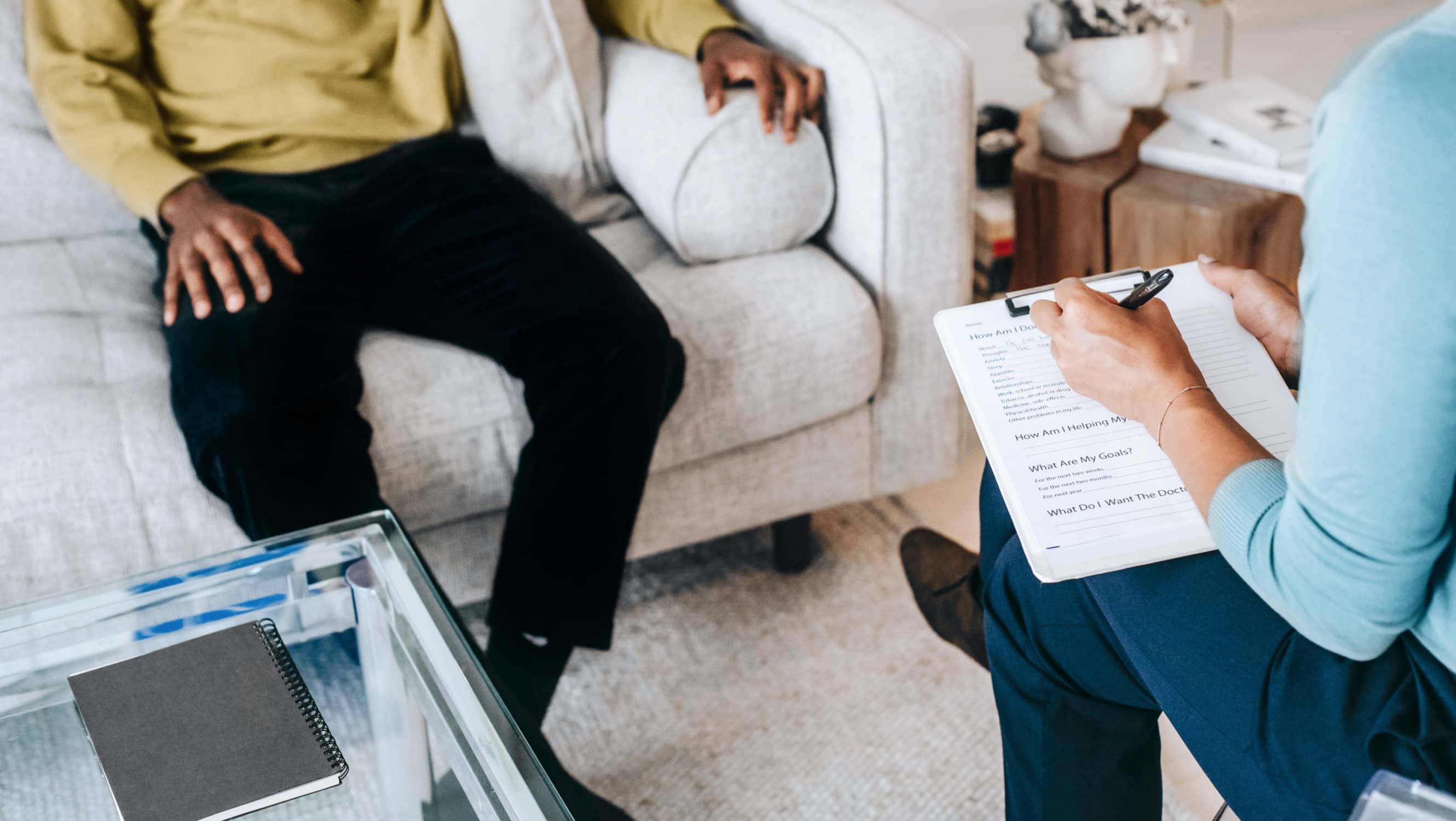 Therapist taking notes during a session in a calm office